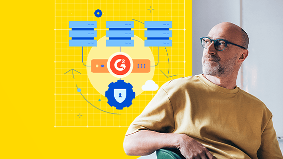 Light-skinned man wearing blue-framed glasses looking at a grid featuring a logo that consists of an orange circle and the G2 logo.